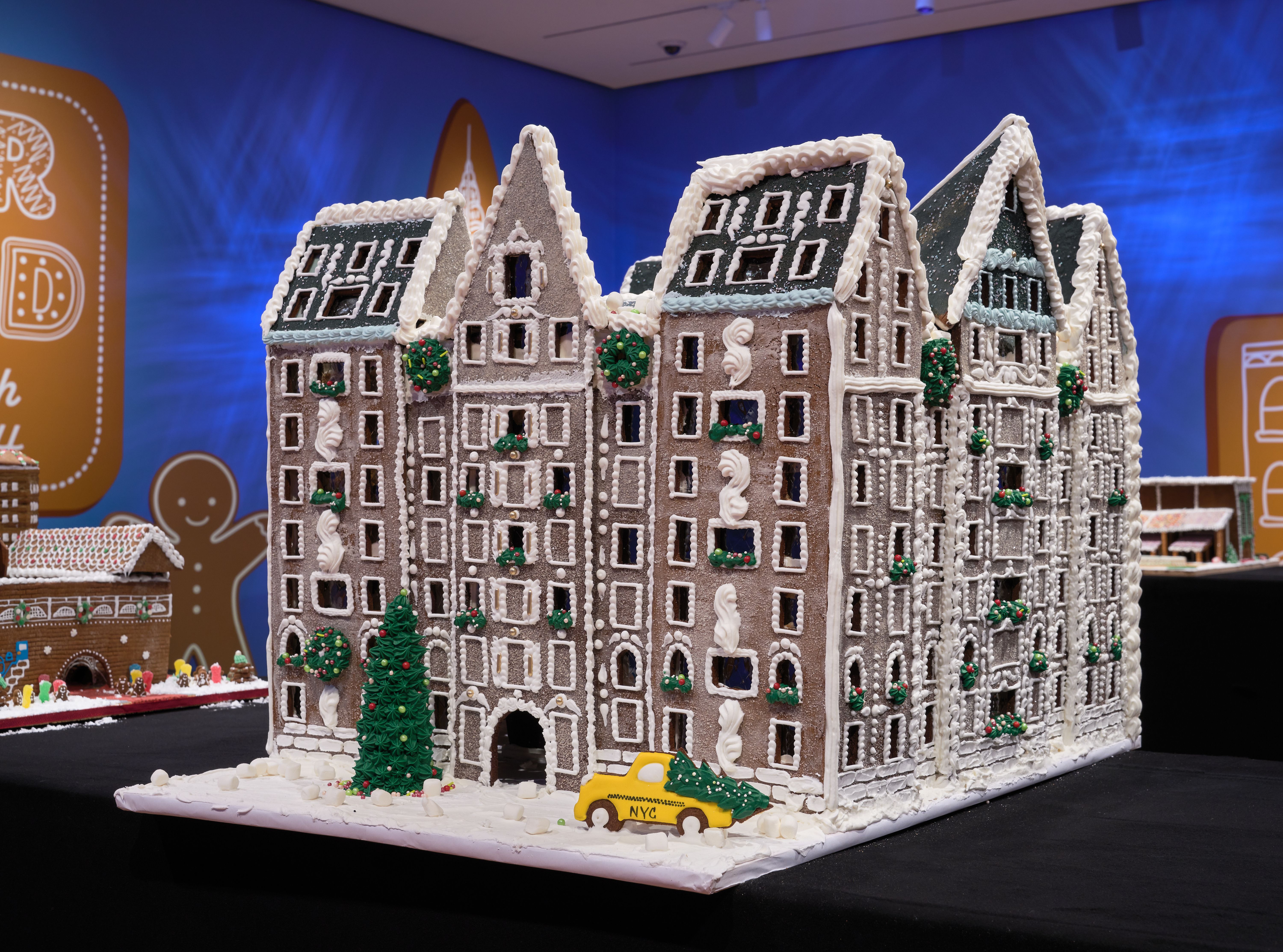 Gingerbread creation of the Dakota Hotel with a yellow taxi out front with snow and Christmas tree